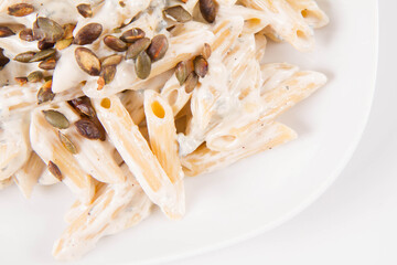 Pasta with blue cheese and cream sauce, sprinkled with roasted pumpkin seeds