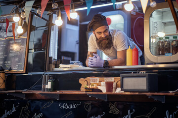 male employee in fast food service waiting for customers leaned on desk