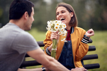 Man giving bouquet of flowers to a woman; Happy couple concept