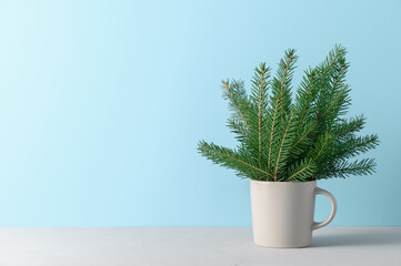 Alternative Christmas tree in gray mug on pastel blue background. Xmas greeting card with copy space.