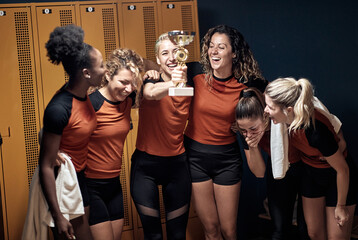 An excited female team celebrating the win and the trophy. Female team sport