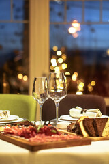 Nicely served New Year's table in the restaurant. Christmas night in a cafe or at home. Stock photo for design