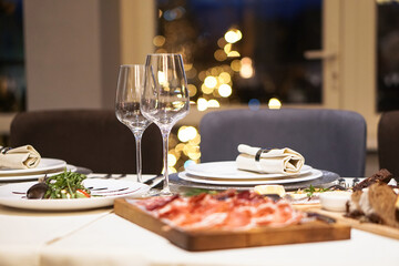 Nicely served New Year's table in the restaurant. Christmas night in a cafe or at home. Stock photo for design