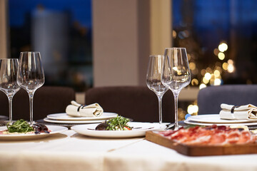 Nicely served New Year's table in the restaurant. Christmas night in a cafe or at home. Stock photo for design