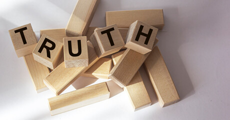 Truth - word from wooden blocks with letters, real facts truth concept, random letters around,...