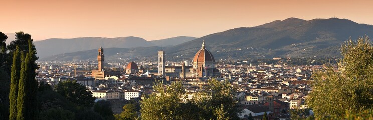 Fototapeta na wymiar Panoramic view of the skyline of the city of Florence at sunset from the hills near Piazzale Michelangelo. Giotto's bell tower and the beautiful Cathedral of Santa Maria del Fiore. Italy.