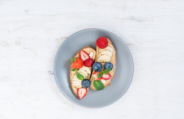 Two tempting sweet peanut Easter sandwiches with berries on a plate. Top view of morning breakfast