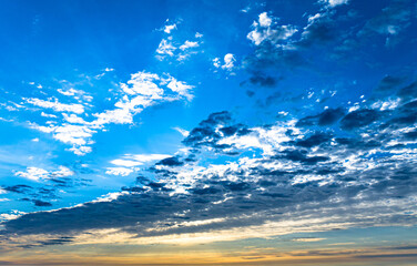 Obraz na płótnie Canvas Dramatic blue sky with multicolor clouds at sunset or sunrise