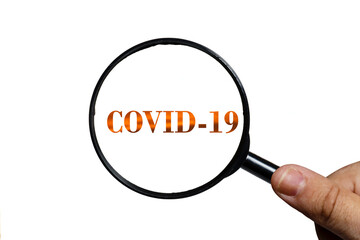 covid 19 and magnifying glass in hand on white background.