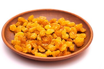 Clay plate with appetizing yellow raisins on white background