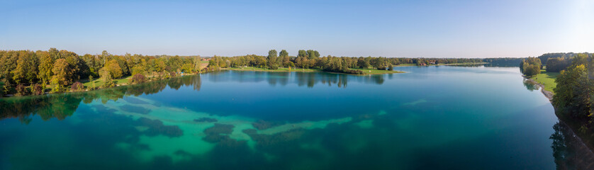 Magnificant panorama of a lake in the north of Munich with dark blue and turquise colors and trees