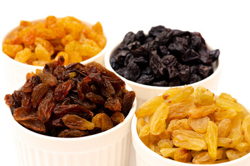 Appetizing raisins of different colors in white plates