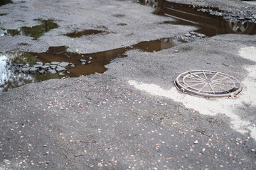 Destroyed road in poor condition requiring repair. Holes in the asphalt are filled with water and...