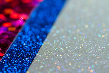 Full frame sparkling silvery white glitter texture background with angled red and blue glitter...