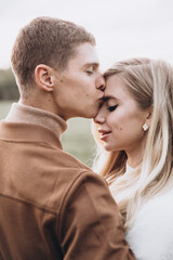 Beautiful young couple in autumn walks with dogs, pomeranian, in the park