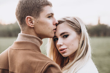 Fototapeta premium Beautiful young couple in autumn walks with dogs, pomeranian, in the park