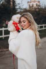 Beautiful young couple in autumn walks with dogs, pomeranian, in the park