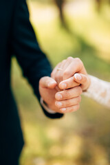 hands of groom and bride hold together