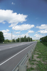 Asphalt road among forests and fields. A beautiful journey by car. Nature stock photo background