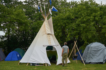 Man looking at the Tippi tent in the campsite © Andrius