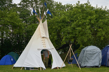 White tall Tippi tent with some flags on top. © Andrius