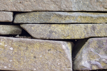 stacked stone wall texture background, close up and full frame