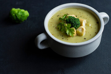 puree soup with herbs and croutons in a white plate