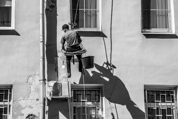 Industrial climber repairing building facade - 389088299