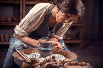 Beautiful ceramist working with pottery at the ceramic workshop. Making pottery.
