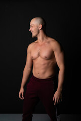 Naklejka premium A sports guy of beautiful strength builds muscles in training. Strong bodybuilder, strong abs, shoulders, biceps, deltoid and palmaris longus.