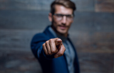 Portrait of a handsome young business man leaning against the wall