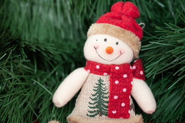 Smiling Christmas snowman handmade in a hat and scarf. Christmas decoration made of fabric.