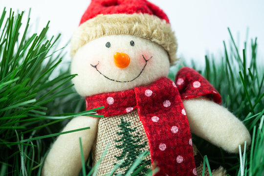 Smiling Christmas snowman handmade in a hat and scarf. Christmas decoration made of fabric.