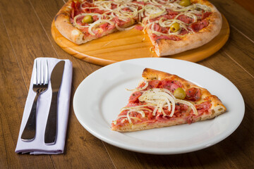 Pepperoni Pizza slice made with slices of onions, mozzarella cheese and green olives.