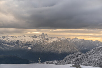 View of Snow Peaked Mountains Against Golden Cloudy Sky