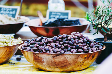 Olives noires dans un bol en vente dans un marché d'épices