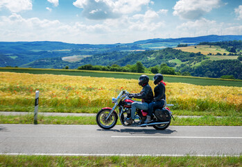 Couple on a motorcycle riding through german summer landscape
