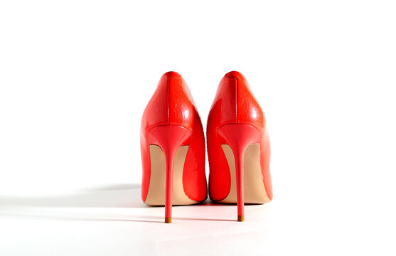 Bright red shoes on the white background. Back view picture. Beautiful high heels shoes. Element for design. Space for text.