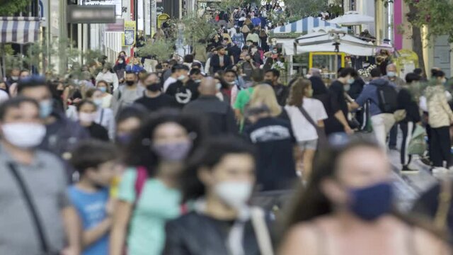 time lapse of a crowd goes up and down a busy shopping street wearing a protective mask for covid19