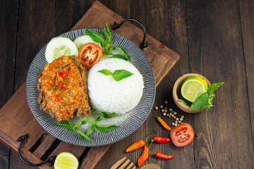 Ayam geprek, Indonesian popular streed food, made from crispy chicken smashed with sambal or chili sauce, eat with rice and cucumber, lettuce, tomato and kemangi. Isolated background, copy space.