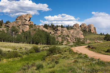 Naklejka na ściany i meble A county road passes by dramatic rock formations in Castle Rock Park in Central Colorado. Castle Park is located within the San Isabel National Forest. 