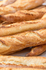 Freshly baked French baguettes lie on a light-colored surface. Rustic handicraft bread, handmade