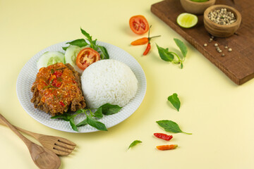 Ayam geprek, Indonesian popular streed food, made from crispy chicken smashed with sambal or chili sauce, eat with rice and cucumber, lettuce, tomato and kemangi. Isolated background, copy space.