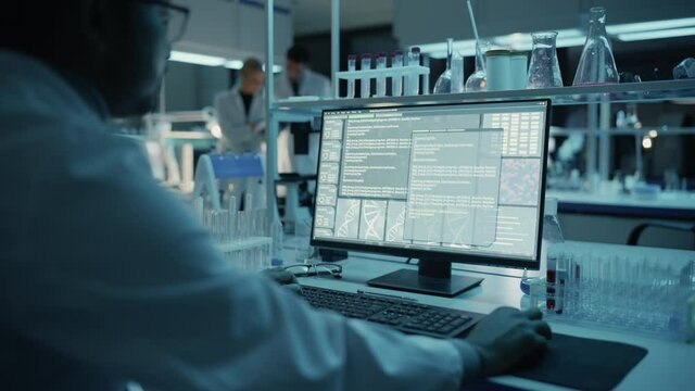 Medical Research Scientist Typing Sophisticated Coding on His Desktop Computer in a Biological Applied Science Research Laboratory