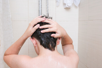 Hygienic procedures and healthy habits of a preteen boy - taking shower and washing hair with shampoo © ReaLiia