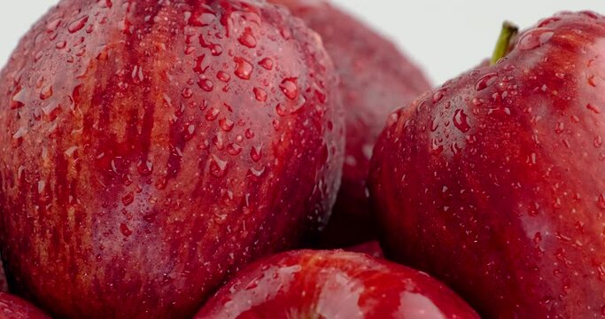 Still shot close up of red apple group pile with water slide down on skin surface, white background
