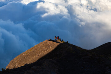 Group of tourists above the clouds descending from the top of Agung mountain, Bali island,...