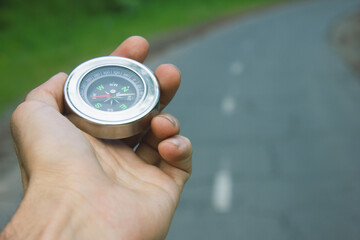 Compass in hand on a background of nature