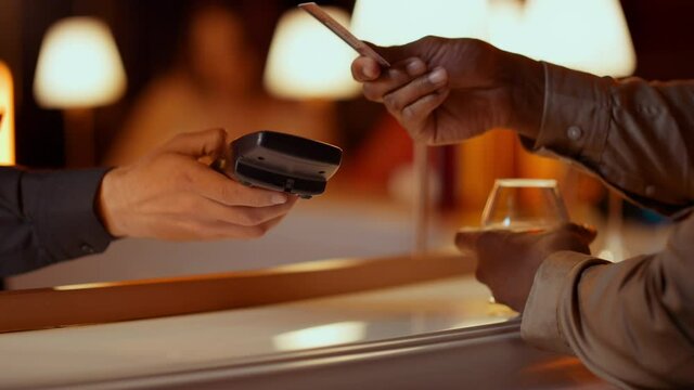 Waiter hand giving bank terminal in bar. Man making contactless payment in club