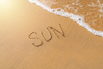 The inscription sun on the sea sand. vacation concept